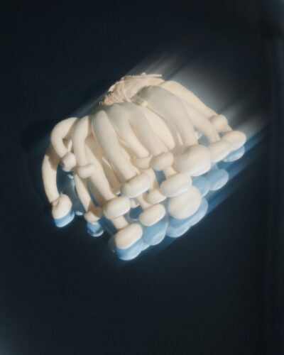 Close-up of a cluster of white mushrooms with soft light and motion blur effect against a dark background.