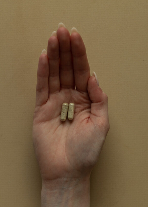A woman's hand with two capsules in the middle of her palm | Curating Your Desired Mushroom Microdose Experience | Sugar Magnolia
