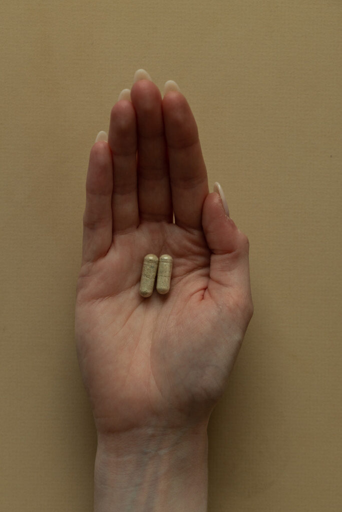 A woman's hand with two capsules in the middle of her palm | Curating Your Desired Mushroom Microdose Experience | Sugar Magnolia