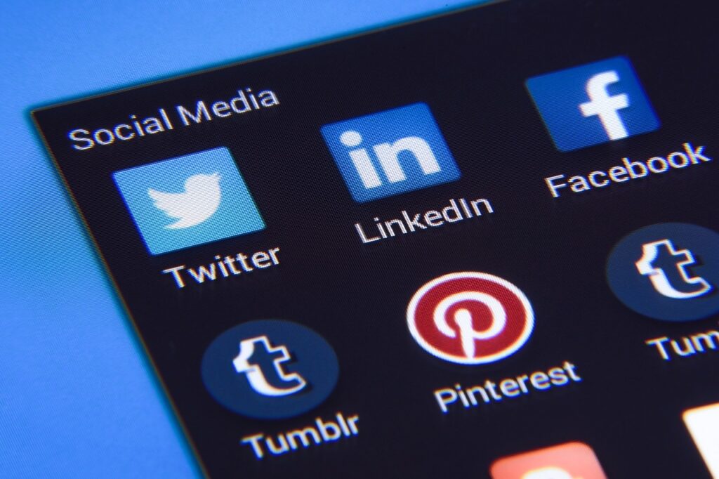 Close-up of smartphone screen displaying popular social media apps like Twitter, LinkedIn, Facebook, Pinterest, and Tumblr, highlighting online community connections.
